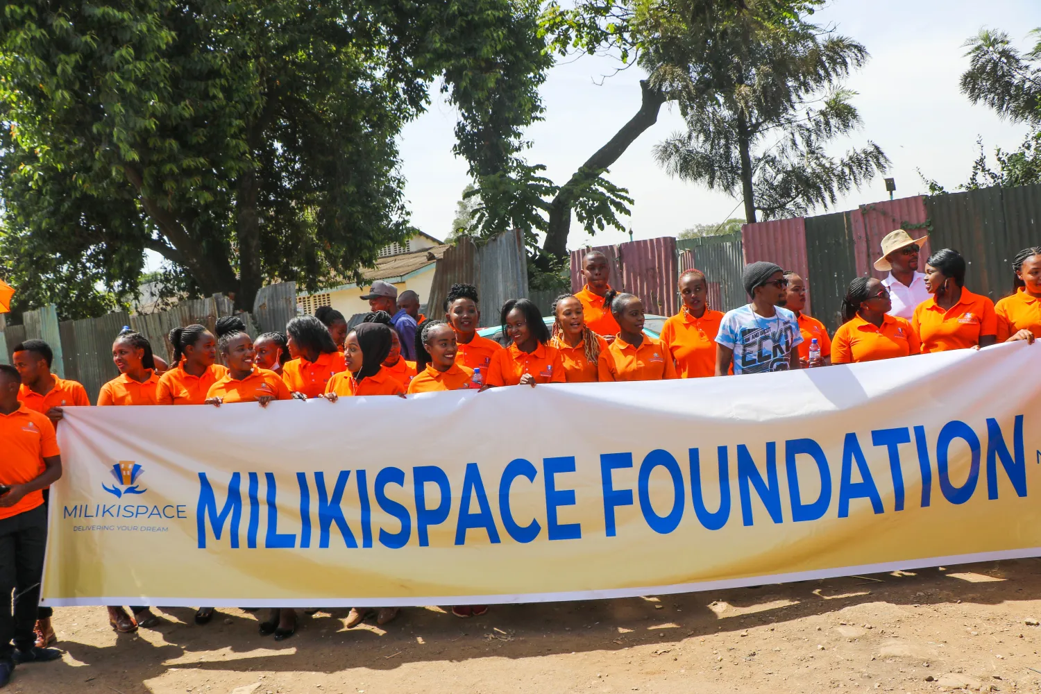 The MilikiSpace Foundation banner carried through the streets