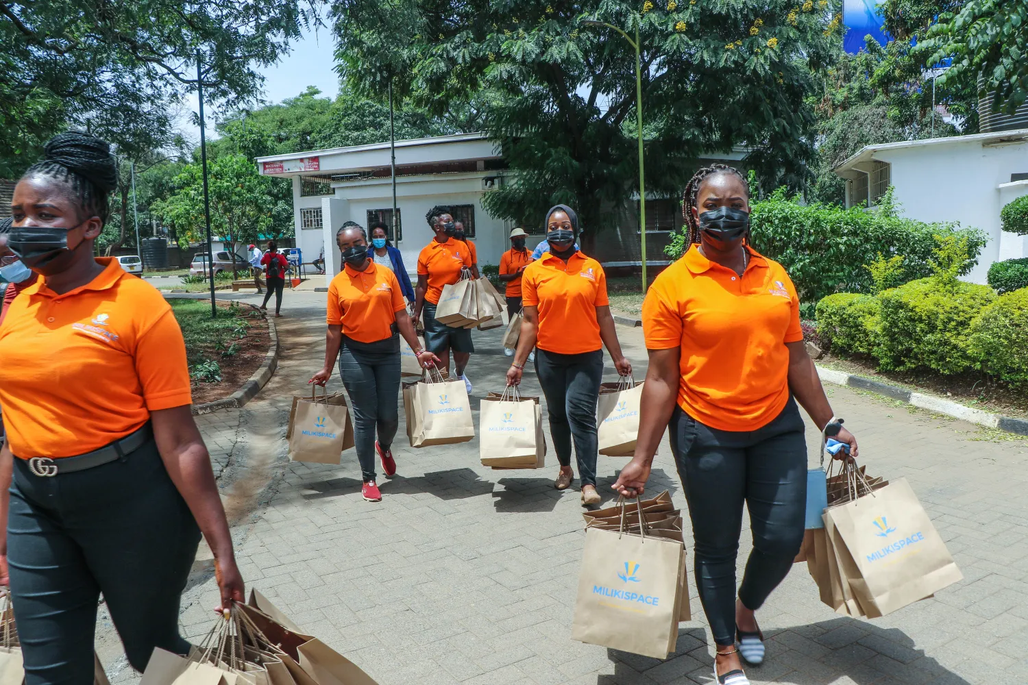 Volunteers carrying gift bags across the hospital grounds
